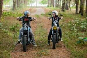 Vento e Taiana, dois motociclistas em suas respectivas motos em uma floresta