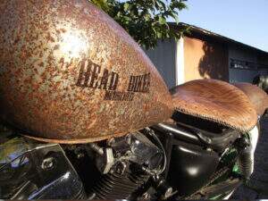 A assinatura da Head Biker Motorcyels no tanque e ao fundo o banco em couro old school