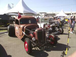 Uma fileira de Hot Rods expostos com seus V8 de fora.