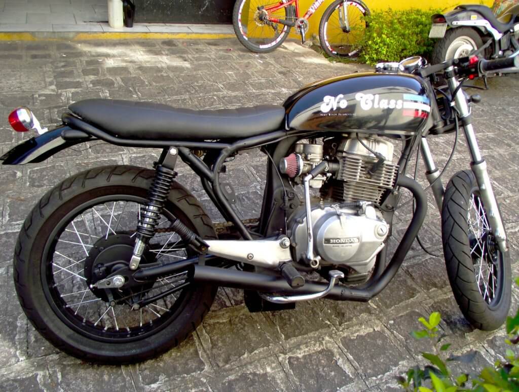 Honda CB 400 cafe racer - No Class, uma moto preta que tem o banco mais baixo seguindo a linha e design do tanque arredondado.