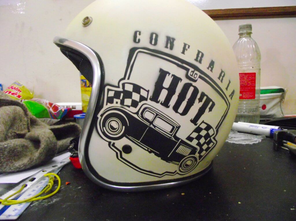 Capacete da confraria do Hot de Curitiba. Capacete branco de lado exibindo o logo em preto.